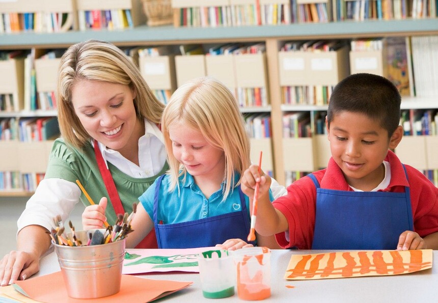 a teacher working with two students in art class