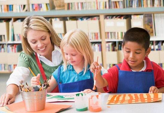 a teacher working with two students in art class