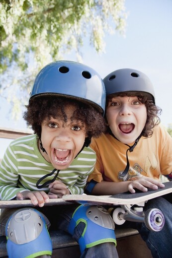 Two Boys with Helmets and Skateboards
